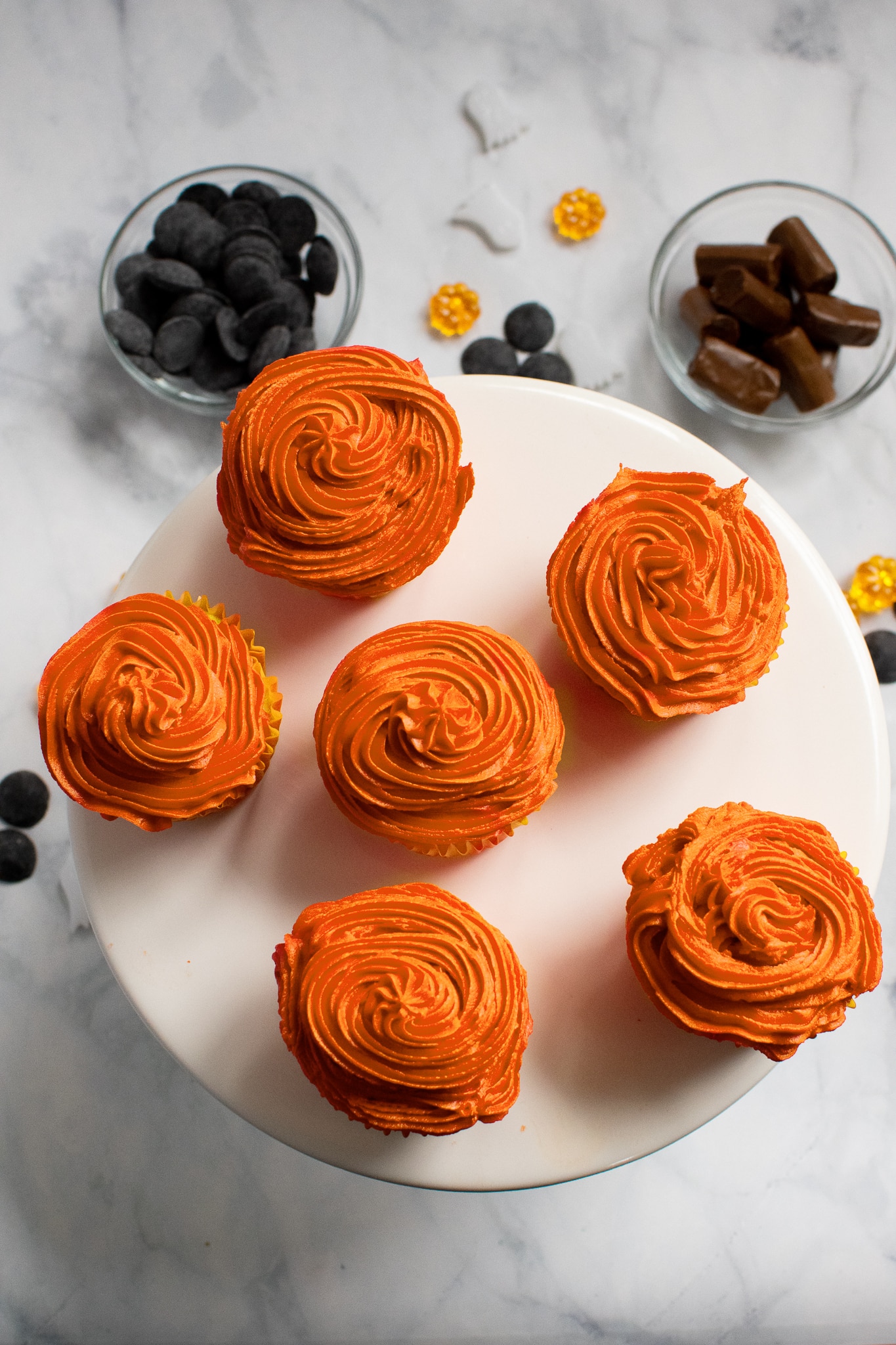 Decorating Mickey Pumpkin Cupcakes with Orange icing.