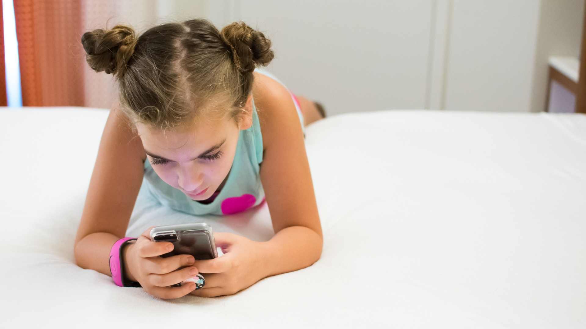 child on phone relaxing in hotel room at Walt Disney World 