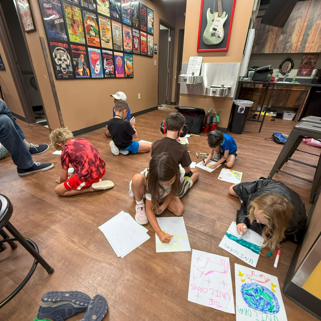 Children drawing in a music studio during School of Rock Summer Camp 