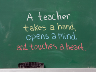 Chalkboard with text "a teacher takes a hand, opens a mind and touches a heart"