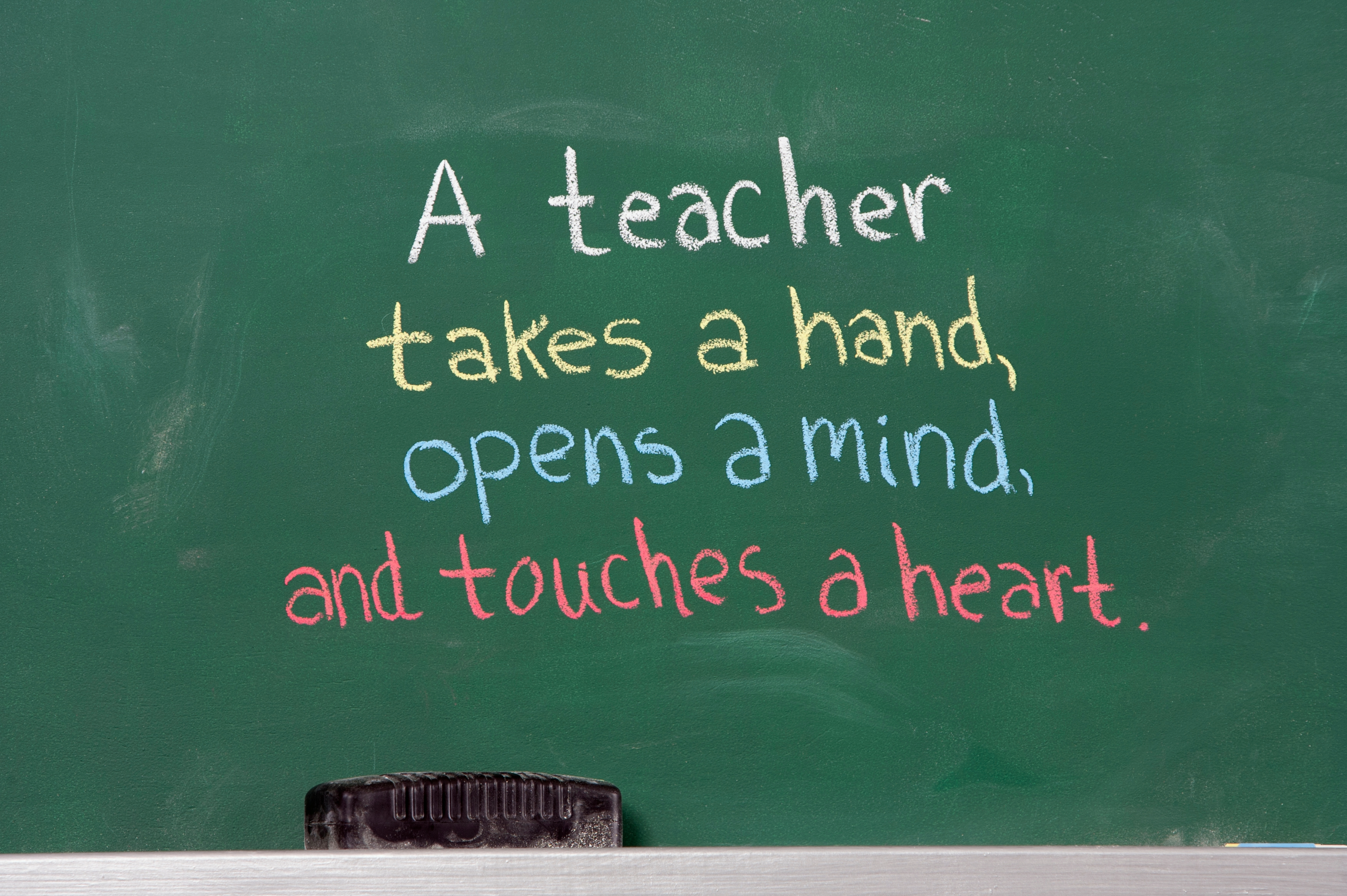 Chalkboard with text "a teacher takes a hand, opens a mind and touches a heart" 